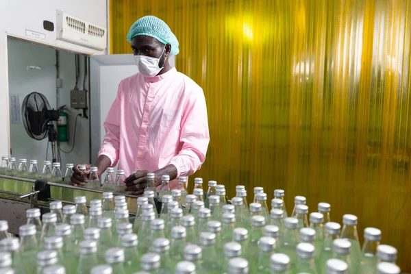 Trabajador Africano Fábrica Que Usa Máscara Médica Recogiendo Botella Jugo — Foto de Stock