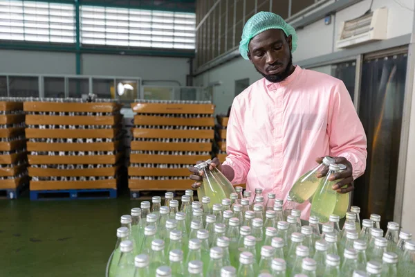 Trabajador Africano Fábrica Recogiendo Botella Jugo Verde Bebida Semilla Albahaca — Foto de Stock