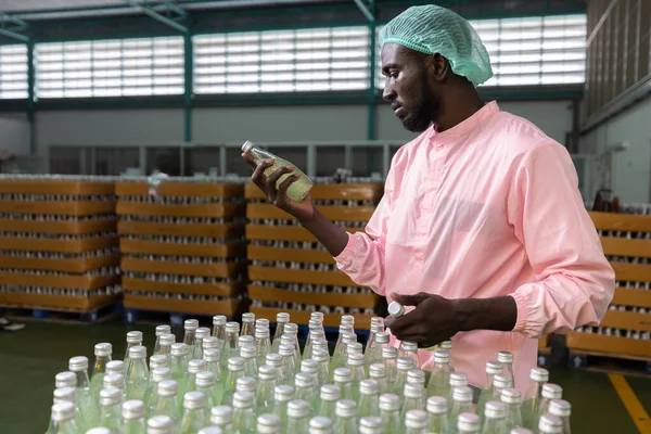Trabajador Africano Fábrica Que Sostiene Mira Botella Jugo Verde Bebida — Foto de Stock