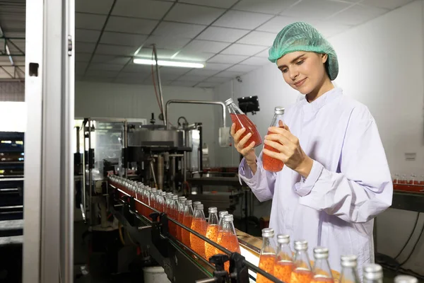 young woman factory worker looking basil seed drink for checking quality in beverage factory