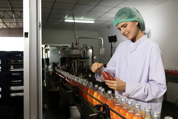 young woman factory worker opening basil seed drink in beverage factory