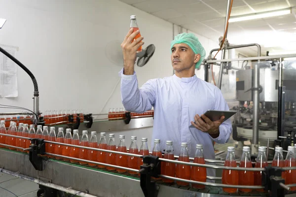Männlicher Fabrikarbeiter Betrachtet Basilikumsaatgetränk Zur Qualitätskontrolle Getränkefabrik — Stockfoto