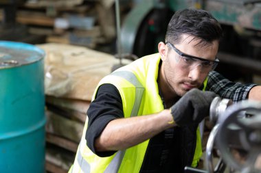 Fabrikadaki makinede çalışan mühendis ya da fabrika işçisi.