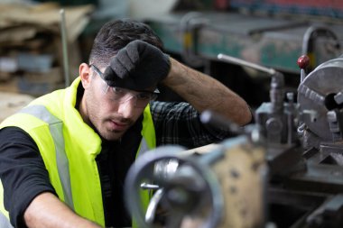 Mühendis ya da fabrika işçisi fabrikadaki makinede çalışmaktan yorgun düşüyor.