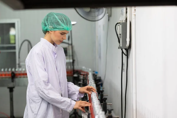 Młoda Kobieta Pracownik Fabryki Patrząc Napój Bazylia Sprawdzania Jakości Fabryce — Zdjęcie stockowe