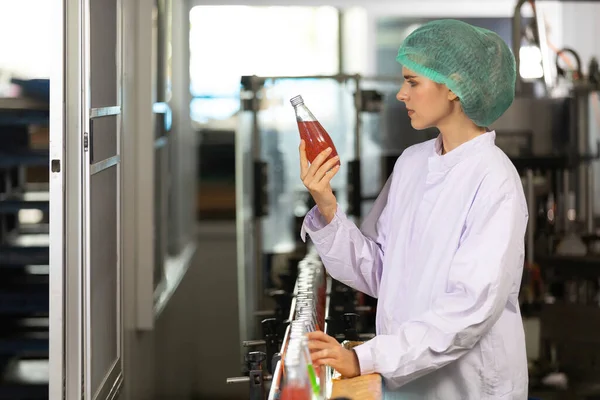 young woman factory worker looking basil seed drink for checking quality in beverage factory