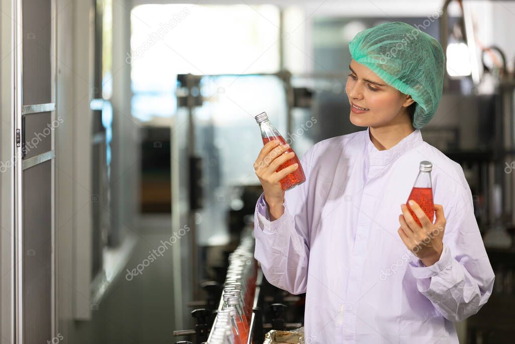 young woman factory worker looking basil seed drink for checking quality in beverage factory