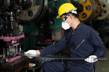 Erkek teknisyen ya da fabrika işçisi virüsü korumak için maske takıyor, fabrikada çalışıyor.