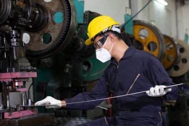Erkek teknisyen ya da fabrika işçisi virüsü korumak için maske takıyor, fabrikada çalışıyor.