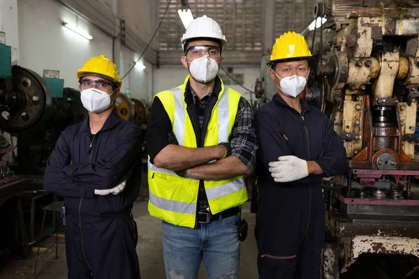 portrait group of industrial technician worker crossed arms post and wearing medical mask for protect virus in factory