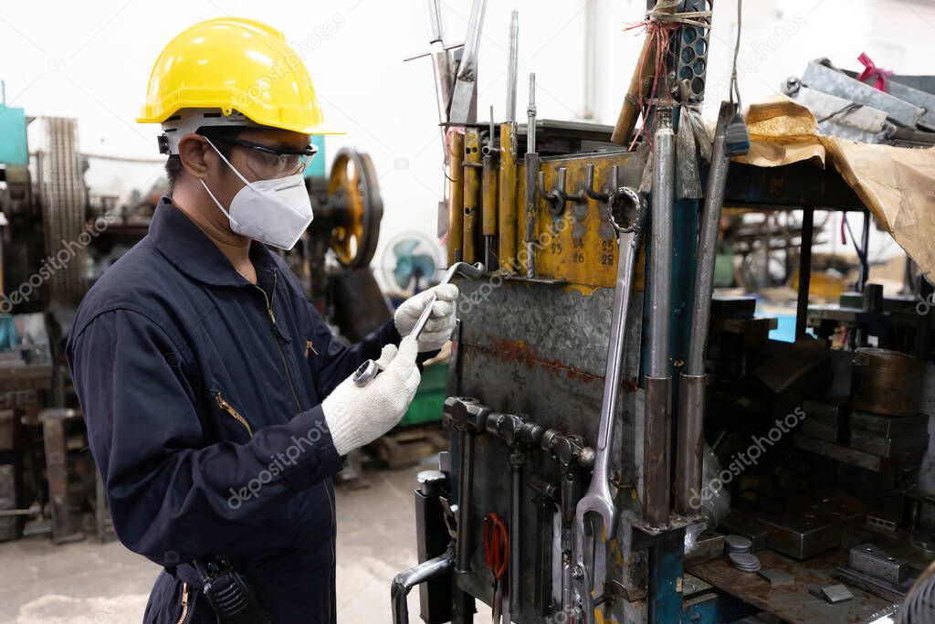 engineer worker or mechanic searching and choosing for the right tool, wearing face mask for protect virus, new normal concept