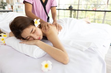 Genç Asyalı güzel kadın güzellik salonunda eğleniyor, uyuyor ve masaj yaptırıyor.