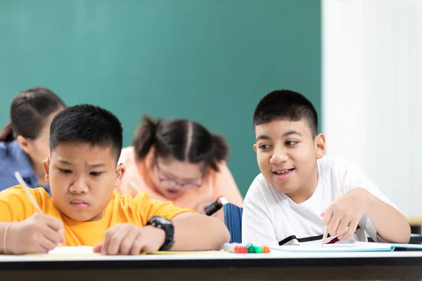 Asiatiska Funktionshindrade Barn Eller Autism Barn Lärande Tittar Och Skriver Stockbild