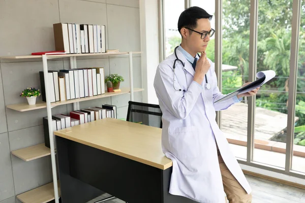 Asian Doctor Reading Medical Report Clipboard Medical Office — Stock Photo, Image