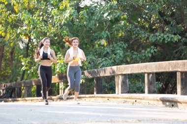 Asyalı atletizm çifti akşam vakti birlikte koşup egzersiz yapıyorlar.