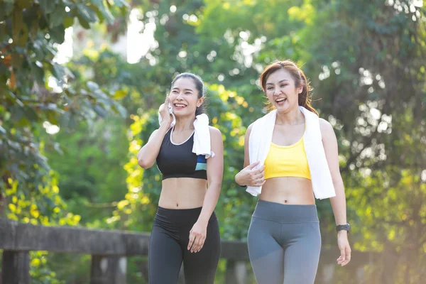 Atletizm çifti kadın, parkta birlikte koşup spor yaptıktan sonra eğleniyor.