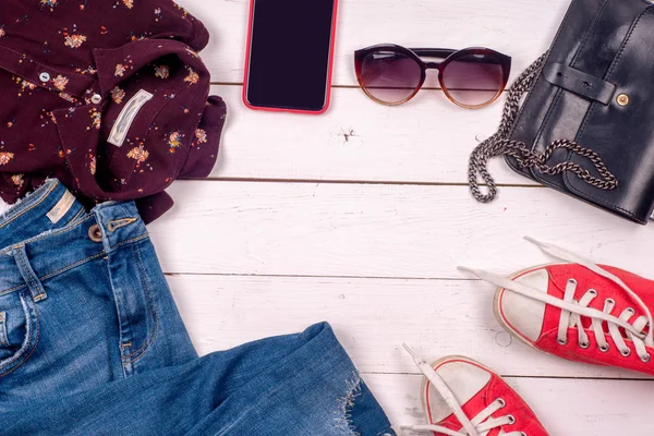 Women clothing set of cool stuff and accessories on light background. Top view.