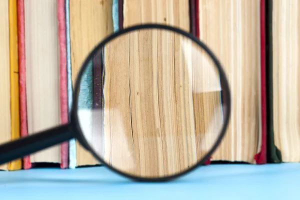 Açık kitap ve Büyüteç camı kompozisyonu. Okula dönüş, uzay kopyalayın. Eğitim arka plan.