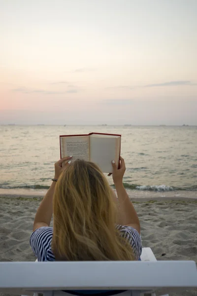 Vrouw leesboek ontspannen in ligstoel — Stockfoto