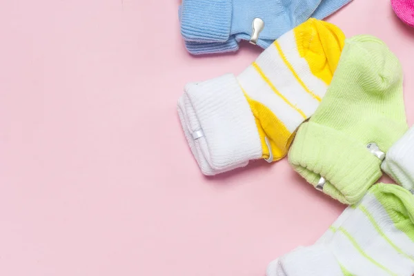 Βαμβάκι Παιδικές κάλτσες για νεογέννητα σε ένα πολύχρωμο φόντο ροζ. Χώρο αντίγραφο — Φωτογραφία Αρχείου