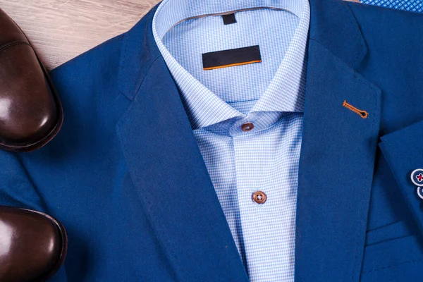 Set di abiti classici da uomo - abito blu, camicie, scarpe marroni, cintura e cravatta su sfondo di legno. — Foto Stock