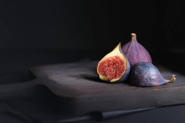 Koyu arkaplanda taze incir. Yaklaş, yumuşak seçici odaklanma. Boşluğu kopyala. 