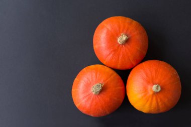Tahta üzerinde olgun bir balkabağı. Turuncu balkabaklı karanlık sonbahar arkaplanı. Yumuşak seçici odaklanma. Üst görünüm.