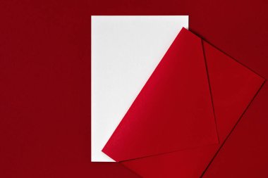 Boş kopya alanı olan kırmızı kağıt desenli kırtasiye şablonu. Beyaz boş kağıt maketi, koyu kırmızı zemin üzerindeki zarf, kartpostal, davetiye veya harf düzeni.