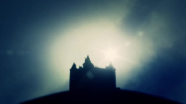 Castillo o un fuerte desde una distancia a través de una niebla sobre un fondo oscuro cielo nublado al amanecer o al atardecer — Vídeo de stock