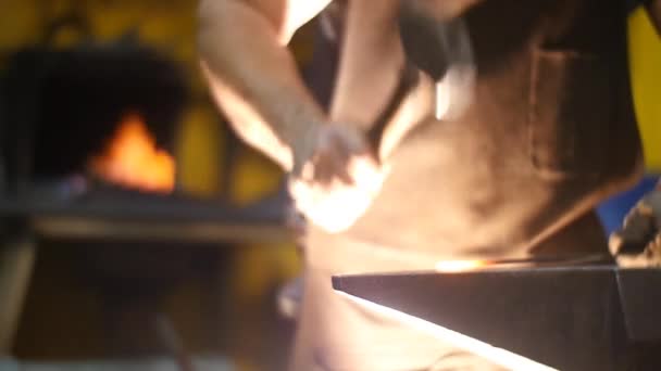 Herrero forjando una espada con martillo en un yunque en un taller de cámara lenta — Vídeos de Stock