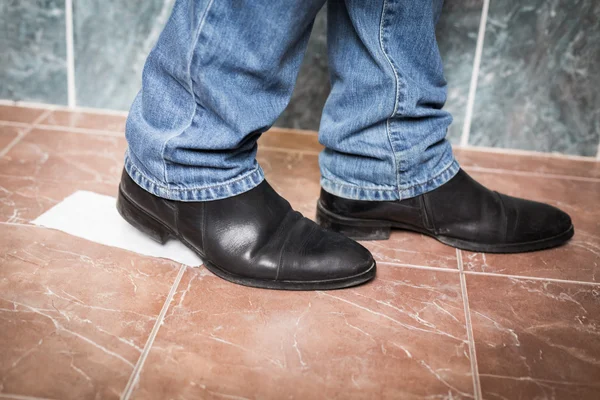 Toilet paper stuck to the sole of a dress shoe — Stock Photo, Image