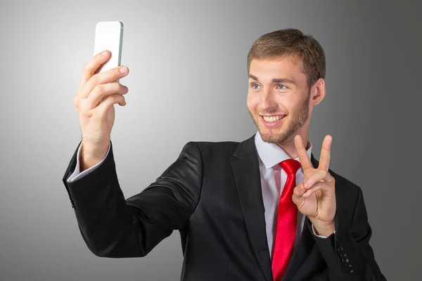 Bir cep telefonu ile bir selfie alarak iş adamı — Stok fotoğraf
