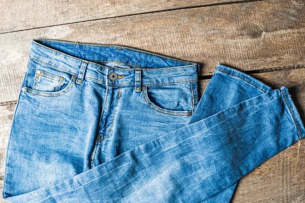 Pantalones vaqueros azules en superficie de madera vieja — Foto de Stock