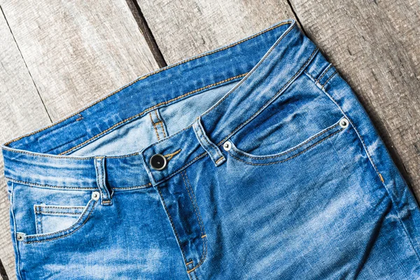 Ahşap arka plan üzerinde kot pantolon