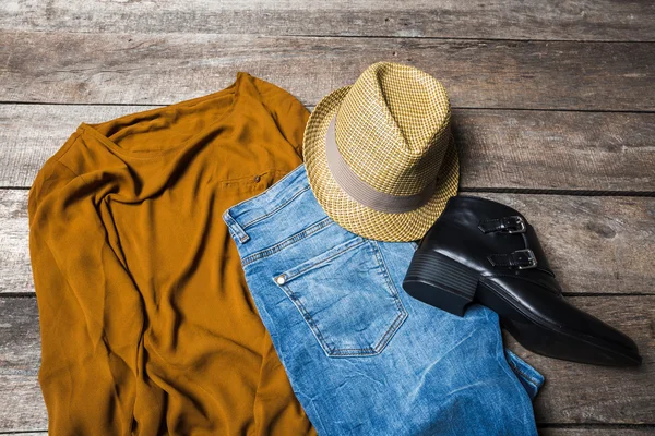 Güzel kadın giyim ahşap arka plan üzerinde kümesi.