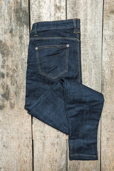 Ahşap arka plan üzerinde kot pantolon