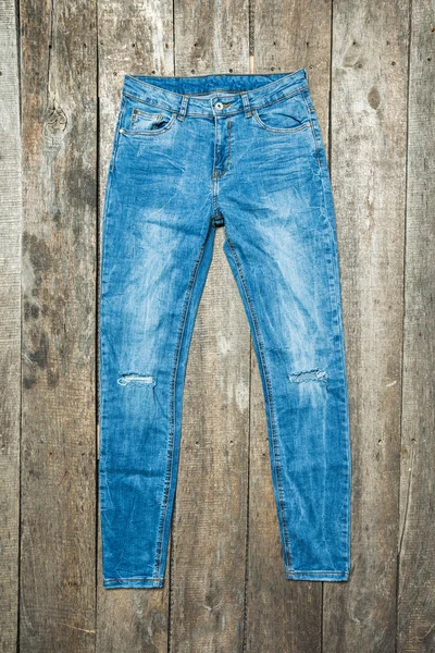 Ahşap arka plan üzerinde kot pantolon