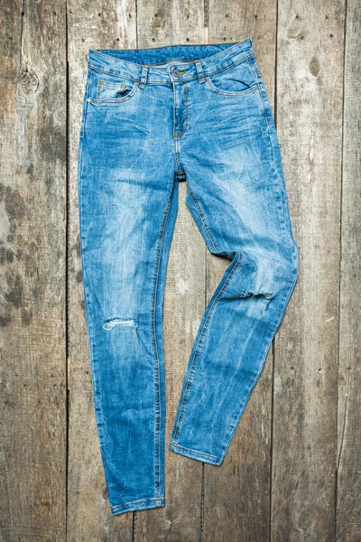 Jeans on a wooden background — Stock Photo, Image