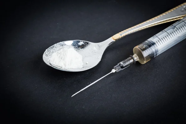 Fecskendő és a kanál főtt heroin — Stock Fotó