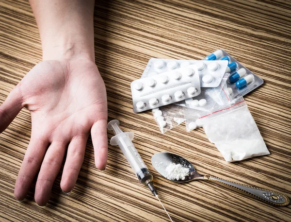Mão viciada em drogas com seringa no chão — Fotografia de Stock