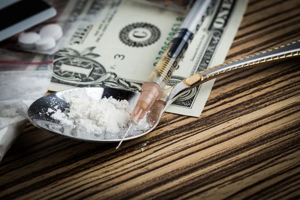 Drogenspritze und gekochtes Heroin auf Löffel — Stockfoto