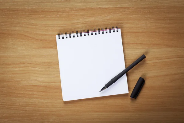 Notebook z pióra na stole — Zdjęcie stockowe