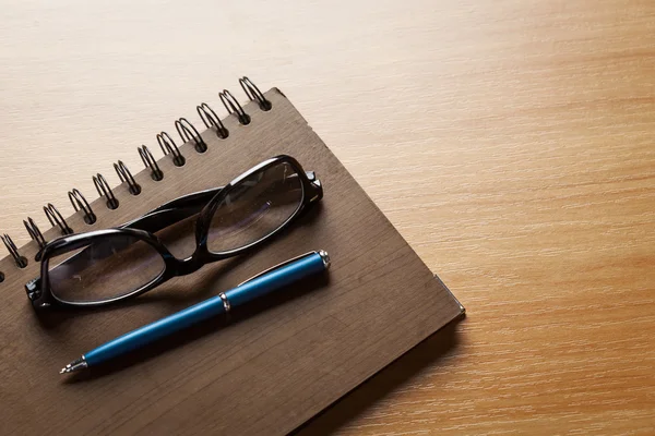Glasögon, anteckningsblock och penna — Stockfoto