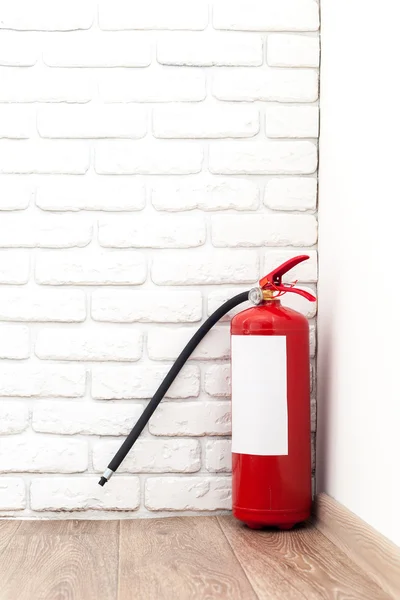 Fire extinguisher near white wall