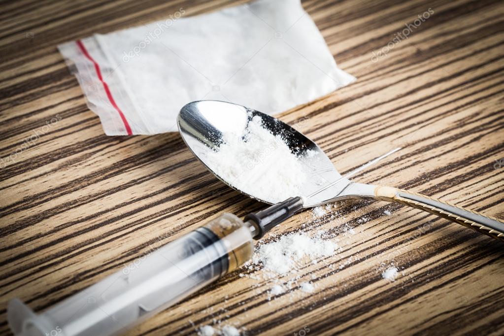 Drug syringe and cooked heroin on spoon