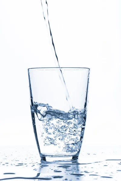 Wasser spritzt aus Glas — Stockfoto