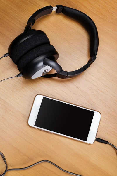 Kopfhörer und iPod auf dem Schreibtisch — Stockfoto