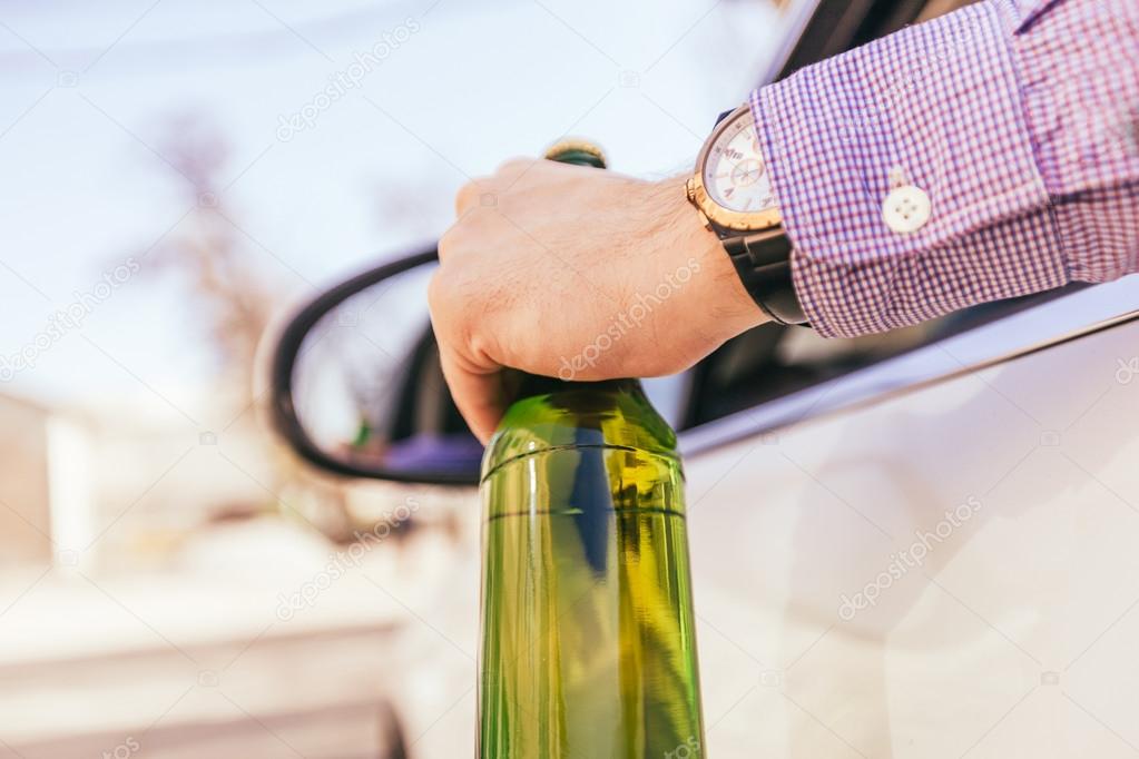 man drinking alcohol while driving the car