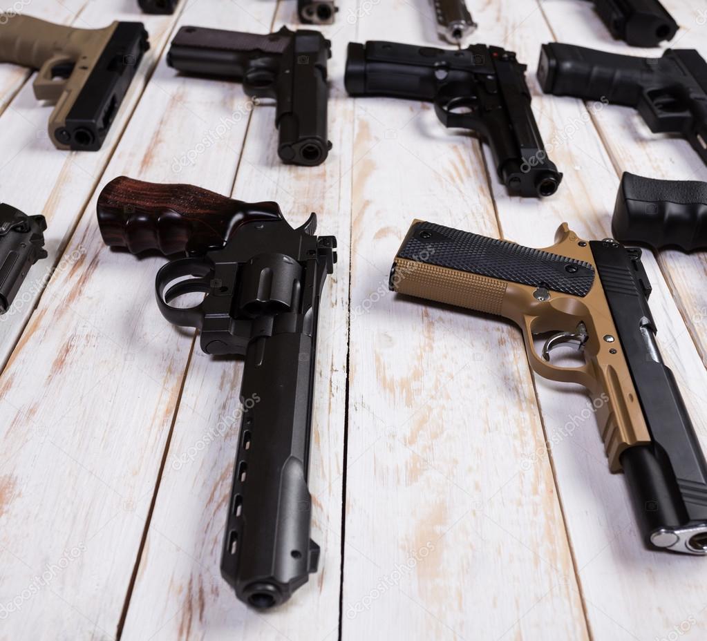 Firearms. Gun. Closeup the gun lies on a wooden white background.