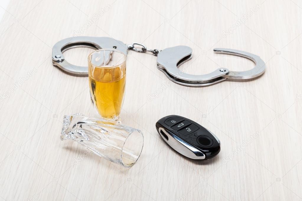 Car key on the bar with spilled alcohol